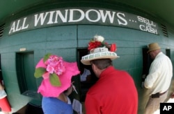 FILE - Fans make wagers before the 140th running of the Kentucky Derby horse race at Churchill Downs in Louisville, Kentucky, May 3, 2014.