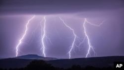 In this photo taken Wednesday, Aug. 9, 2017 a strike of lightning illuminates the sky over Annaberg-Buchholzer, southeastern Germany. (Bernd Maerz/dpa via AP)