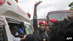 FILE - Ugandan singer-turned-politician Robert Kyagulanyi, center, better known as Bobi Wine, reacts as he gets into an ambulance after being released on bail at The High Court in Gulu, northern Uganda, Aug. 27, 2018.