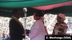 FILE - Priscilla Chigumba, right, head of Zimbabwe Electoral Commission, talks with President Emmerson Mnangagwa in Harare, Aug. 26, 2018.