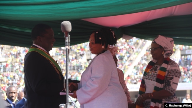 FILE - Priscilla Chigumba, right, head of Zimbabwe Electoral Commission, talks with President Emmerson Mnangagwa in Harare, Aug. 26, 2018.