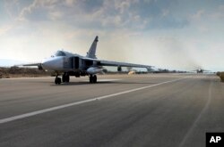 In this photo taken from Russian Defense Ministry official website on Oct. 6, 2015, a Russian SU-24M jet fighter prepares to take off from an airbase Hmeimim in Syria.