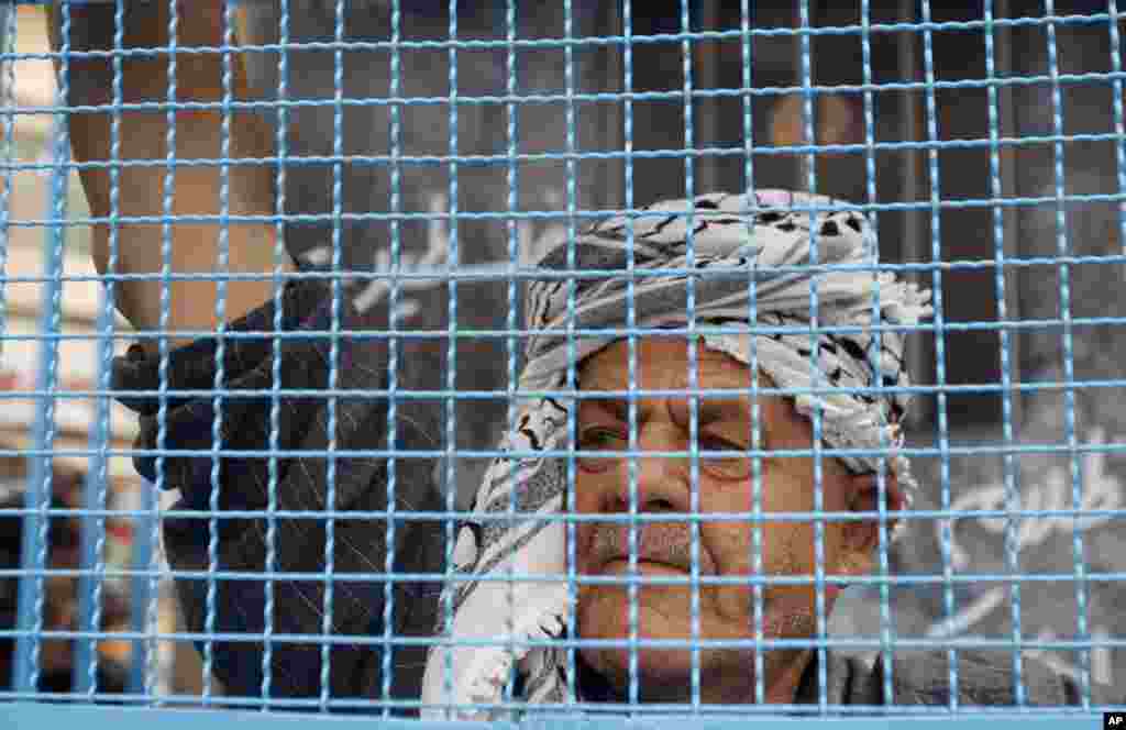 A Palestinian man stands in a symbolic prison cell during a protest supporting Palestinian inmates on hunger strike in Israeli jails, in the West Bank city of Ramallah, May 14, 2012. 