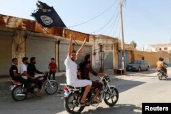 FILE - A resident of Tabqa city on a motorcycle waves an Islamist flag in nearby Raqqa, Syria, Aug. 24, 2014. To win over locals populations, IS distrubutes food and other essential supplies to ordinary people and buys allegiances of local leaders with money and by giving them authority.