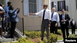U.S. President Barack Obama, with New Orleans Mayor Mitch Landrieu at his back, chats with residents in a part of the Louisiana city reconstructed after Hurricane Katrina, Aug. 27, 2015.