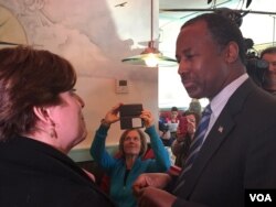 Presidential candidate Ben Carson talks with a woman at the Airport Diner in Manchester, New Hampshire, Feb. 7, 2016. (K. Gypson/VOA)