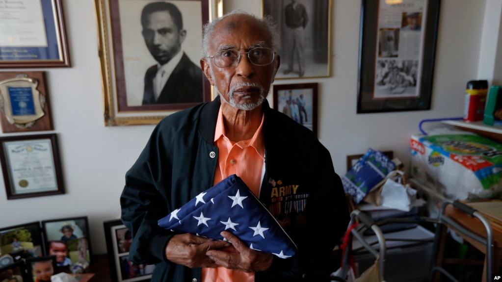 World War II veteran Johnnie Jones, Sr. poses for a portrait at his home in Baton Rouge, La., Tuesday, May 28, 2019. He remembers wading ashore and one incident when he and his fellow soldiers came under fire from a German sniper. (AP Photo/Gerald Herbert)