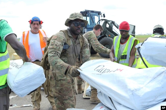 Members of the US army help load supplies at Beira International airport, Mozambique, Monday, April 1, 2019, joining the humanitarian aid efforts following a cyclone that hit the country on March 14.