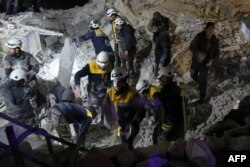 Syrian emergency personnel search for victims following an explosion at a base for Asian jihadists in a rebel-held area of the northwestern city of Idlib, Jan. 7, 2018.