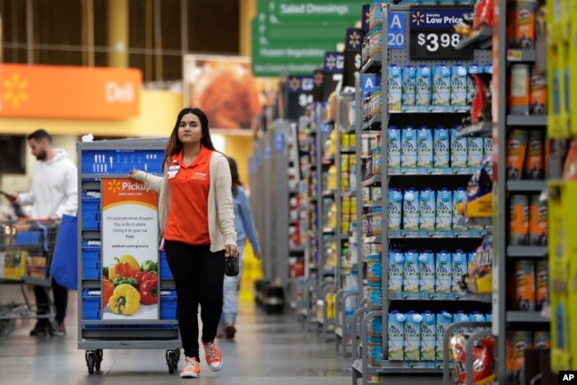 Laila Ummelaila, yang bekerja di toserba Walmart, menyiapkan barang-barang yang dipesan secara daring oleh pembelanja pribadi (personal shoppers).