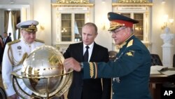 Russian President Vladimir Putin, center, Defence Minister Sergei Shoigu, right, and Commander-in-Chief of the Russian Navy Admiral Vladimir Korolev, left, visit the Main Admiralty historical building during the Navy Day celebration in St.Petersburg Sunday. Putin Sunday ordered new sanctions against the United States. (Alexei Nikolsky, Sputnik, Kremlin Pool Photo via AP)