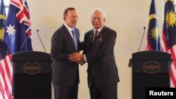 Australian Prime Minister Tony Abbott (L) and his Malaysian counterpart Najib Razak shake hands at a joint news conference in Putrajaya, Sept. 6, 2014. 