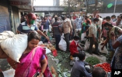 Indians crowd a vegetable market in Mumbai, India, Wednesday, March 25, 2020.