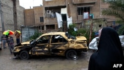 Local residents gather at the site of a car bomb explosion in the Hurriyah neighborhood of Baghdad, Feb. 3, 2014.