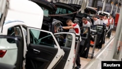 Workers assemble vehicles on the assembly line of the SEAT car factory in Martorell, near Barcelona, Spain, Oct. 31, 2018.