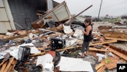 Jennifer Bryant looks over the debris from her family business destroyed by Hurricane Harvey, in Katy, Texas, Aug. 26, 2017.