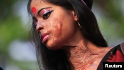 Hasina, a survivor of an acid attack, takes part in an awareness rally about the violence against women...