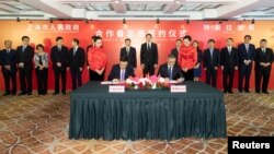 特斯拉公司首席执行官埃隆·马斯克和上海市长应勇于2018年7月10日在上海出席签字仪式。