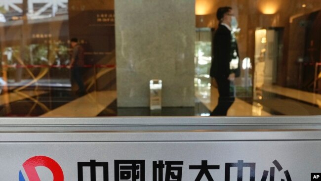 FILE - A security guard stands at the headquarters of China Evergrande Group in Hong Kong, Oct. 4, 2021.