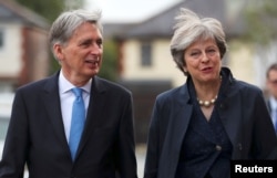 Britain's Prime Minister Theresa May and Chancellor of the Exchequer Philip Hammond visit a home near the Conservative Party's conference in Manchester, Oct. 2, 2017.