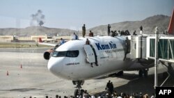 Афганцы, стремящиеся покинуть страну после захвата талибами Кабула, осаждают самолет в Международном аэропорту имени Хамида Карзая