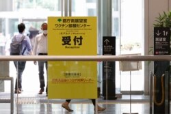 n Papan nama kampanye vaksinasi virus corona terlihat di gedung Pemerintah Metropolitan Tokyo di Tokyo, Jumat, 25 Juni 2021. (Foto: AP)