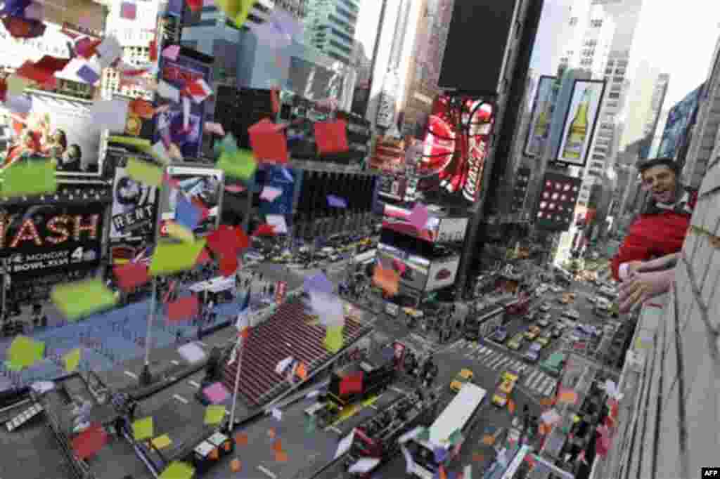 Times Square Alliance President Tim Tompkins throws a handful of confetti from eight stories above onto the streets of Times Square, Thursday, Dec. 29, 2011 in New York. The airworthiness test is in preparation for the release of one ton of confetti by ha