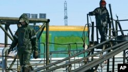 FILE - Oil workers prepare to pump water into the Priobskoye oil field in Western Siberia, which once belonged to the Yukos oil company and were bought by state oil company Rosneft, after a controversial auction in 2004.