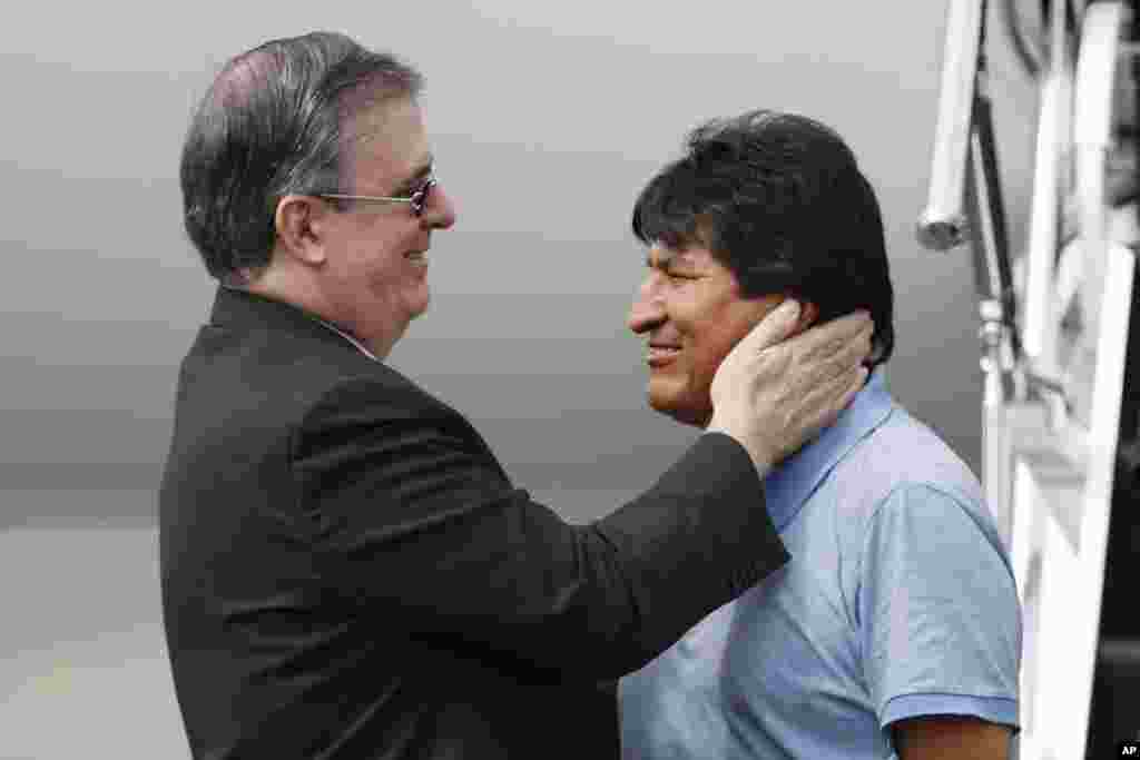 Mexican Foreign Minister Marcelo Ebrard, left, welcomes former Bolivian President Evo Morales upon his arrival to Mexico City. Mexico granted asylum to Morales, who is under mounting pressure from the military and the public after his re-election victory triggered weeks of fraud allegations and deadly protests.