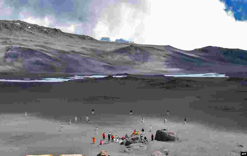 Cricketers play on an ice-covered crater of Kilimanjaro mountain, Tanzania. The game is an attempt to play the world's highest game of cricket, breaking the previous record set in 2009 on Mount Everest.