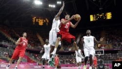 Tunisia's Makram Ben Romdhane (12) is defended by Nigeria's Koko Archibong (10) during the first half of a preliminary men's basketball game at the 2012 Summer Olympics, London, July 29, 2012.
