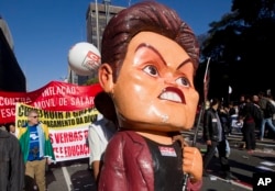 A striking worker carries a large effigy of Brazil's President Dilma Rousseff during a protest in Sao Paulo, Brazil, July 11, 2013.