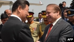 Chinese President Xi Jinping, left, greets Pakistan's Prime Minister Nawaz Sharif at Nur Khan air base in Rawalpindi, in this handout photograph released by Pakistan's press department on April 20, 2015. 