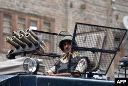 An Indian paramilitary trooper looks out from an armoured vehicle as he takes part in a patrol on a street in Srinagar on August 2, 2016.