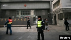 Policemen stand guard in front of a court where Chinese dissident Zhao Changqing's trial is being held in Beijing, Jan. 23, 2014.