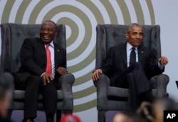 South African President Cyril Ramaphosa, left, and former U.S. President Barack Obama share a light moment at the 16th Annual Nelson Mandela Lecture at the Wanderers Stadium in Johannesburg, South Africa, July 17, 2018.