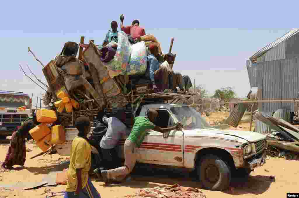 Displaced Somali families help push a pick-up truck carrying personal belongings from a camp which was closed down early morning by Somali forces, leaving hundreds of families without shelter, in the capital Mogadishu.