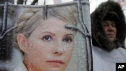 Người biểu tình cầm hình cựu Thủ tướng Yulia Tymoshenko bên ngoài tòa án ở in Kiev, Ukraina