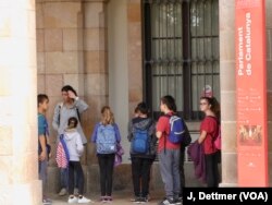 Crocodile lines of school-kids have to pick their way through the media before they get their tours of the Catalan parliament.