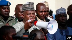 Borno state governor, Kashim Shettima (c), addresses demonstrators who were calling on the government to rescue the kidnapped schoolgirls of the Chibok secondary school, in Abuja, Nigeria, May 13, 2014.