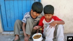 Two children share food at a Buenos Aires soup kitchen after receiving shoes in TOMS "Shoe Drop 2006," which donated the company's first 10,000 pairs of shoes in soup kitchens, schools, and to homeless Guarani Indians in the Northern Argentine jungle (200