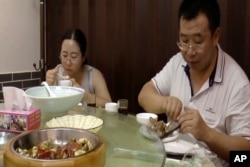 FILE - This image made from Aug. 1, 2016 video shows Chen Guiqiu, left, has lunch with lawyer Jiang Tianyong after attending a trial for human rights lawyer and activists at the Tianjin No. 2 Intermediate People's Court in Tianjin, China.