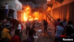 Somali traders attempt to salvage some of their wares from the burning stalls at the main Bakara market in Somalia's capital Mogadishu, Feb. 27, 2017. 