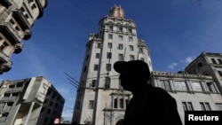 FILE - A man walks in front of the headquarters of Cuba's state-run telecommunications provider ETECSA in Havana, Oct. 24, 2014. 