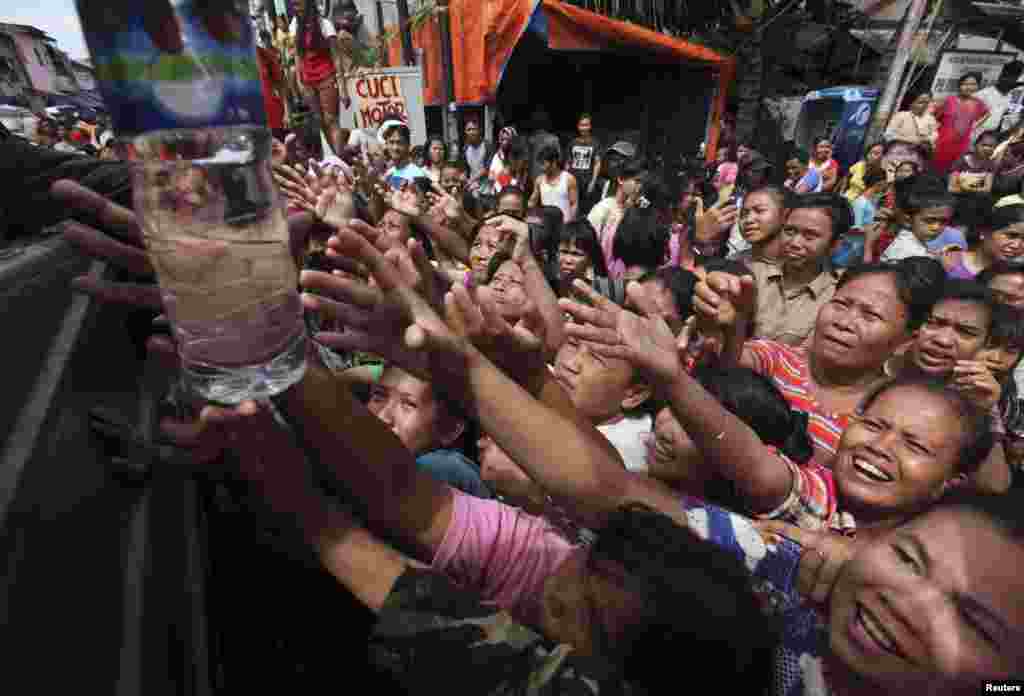 Flood victims scramble for drinking water at Pluit district in Jakarta, Indonesia. Severe floods left more than 18,000 people homeless.