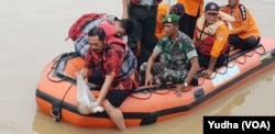 Walikota Solo, Rudy (depan (batik merah berpelampung) melepas kantong plastik berisi ratusan bibit ikan di Bendung tirtonadi Solo, obyek wisata air baru di Solo, Kamis (21/3). (Foto: VOA/Yudha)