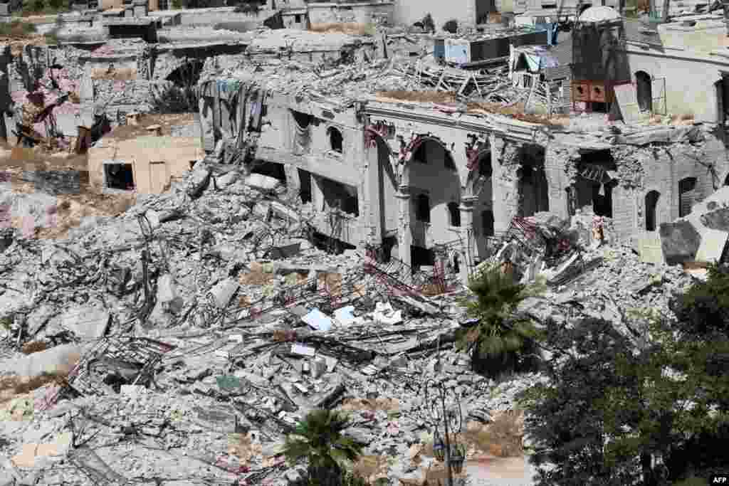 Partially collapsed building of the famed Carlton Citadel Hotel (L), in the government-controlled side of the divided northern Syrian city of Aleppo