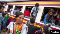 Cambodian workers get off a train as they prepare to migrate back to Cambodia at Aranyaprathet train station in Sa Kaew June 15, 2014. 