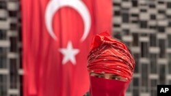伊斯坦布爾的塔克西姆廣場上一位抗議者站在國旗前面