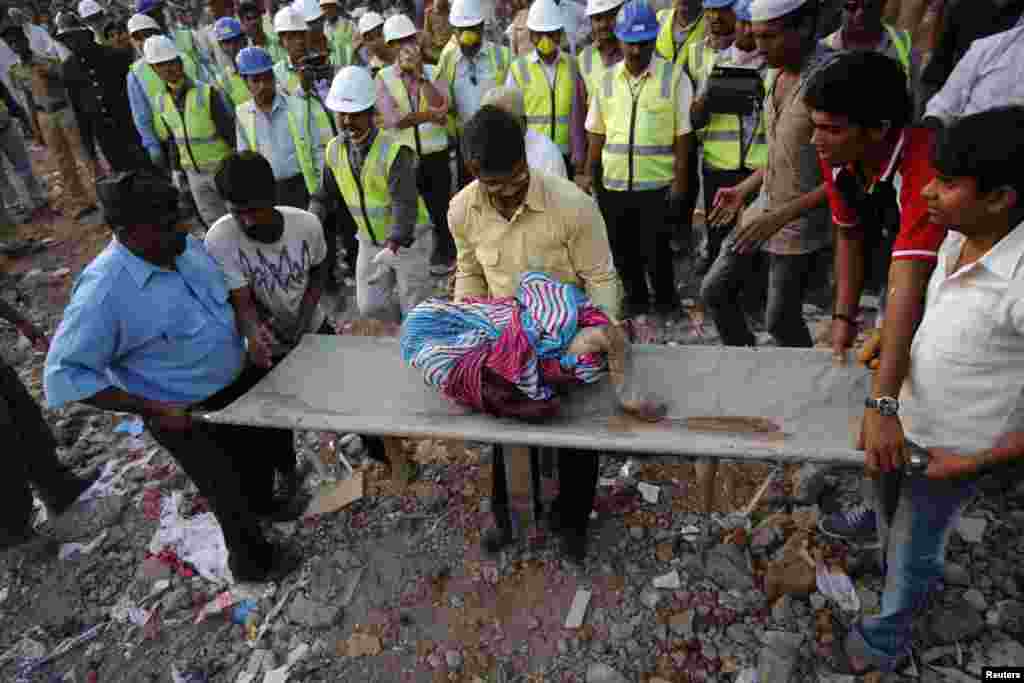 5일 인도 뭄바이에서 발생한 붕괴사고 현장에서 구조대원들이 어린이의 시신을 옮기고 있다. 